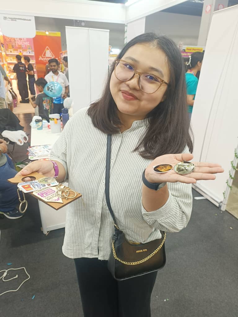 A visitor holding custom photo keychains printed on the spot